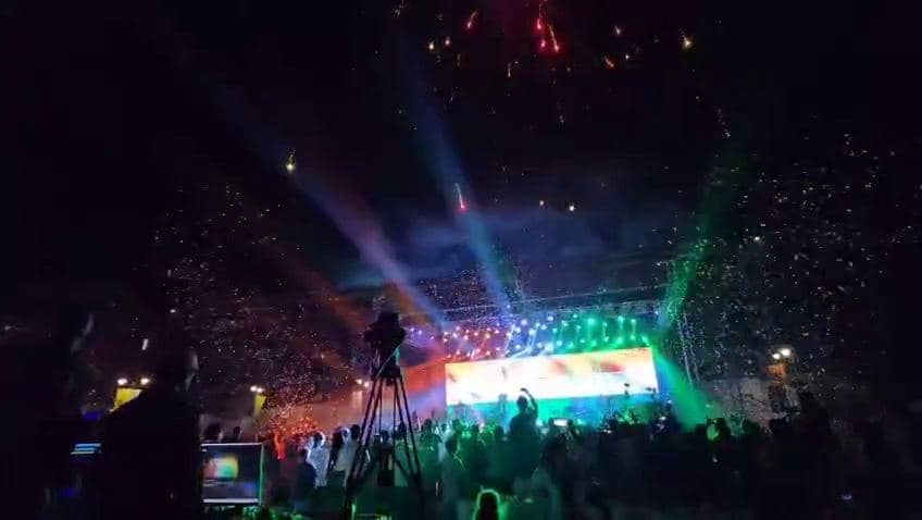 Laser beams and coloured stage lighting over a crowd