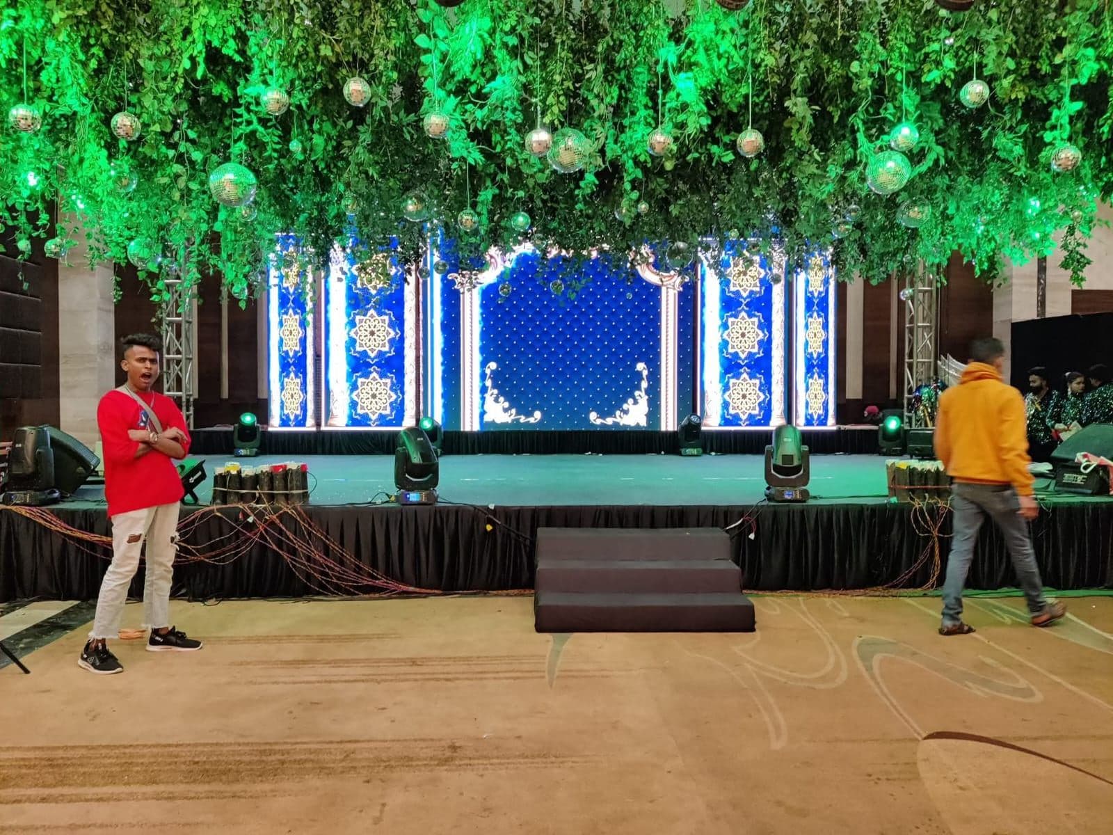 Wedding stage with hanging greenery decor and LED backdrop